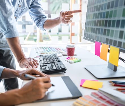 Young colleagues designers working together on a creative project and color samples for selection, Color swatch samples, Brainstorming Planning Partnership, creative graphic design working desktop.